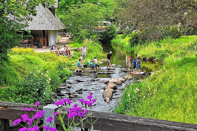 Gerne verweilen Eltern und Kinder, so wie hier am Dorffestsonntag, auch zum im Wasser spielen an der Kirnach, die am Mühlenplatz vorbei ...