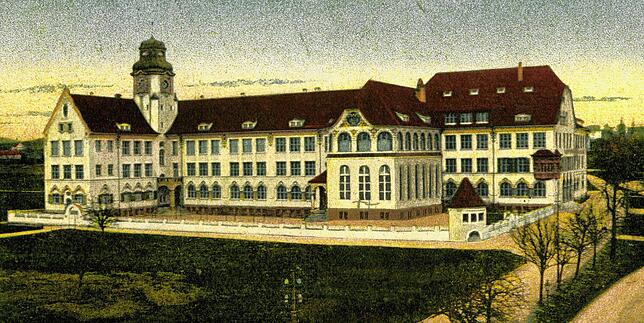 Eine Postkarte um 1910 zeigt das neue, imposante Schulgebäude. Auf der Rückseite ist die Karte beschriftet mit „Volksschule ...