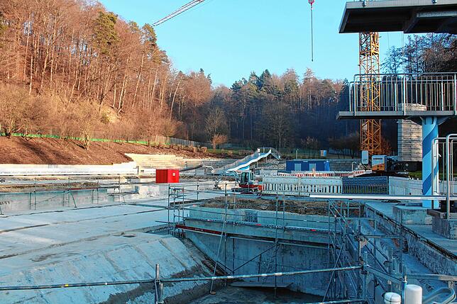 Links vom roten Container ist eine Lücke in der Wand erkennbar. Hier wird eine neue Treppe zum Schwimmerbecken entstehen.