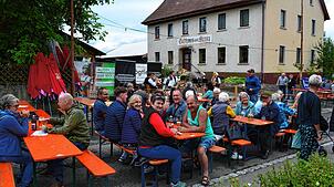 Wegen Platzmangels beim Dorfplatzfest wird die für den Verkehr gesperrte Unterdorfstraße genutzt. Im Hintergrund spielt die Musikkapelle ...