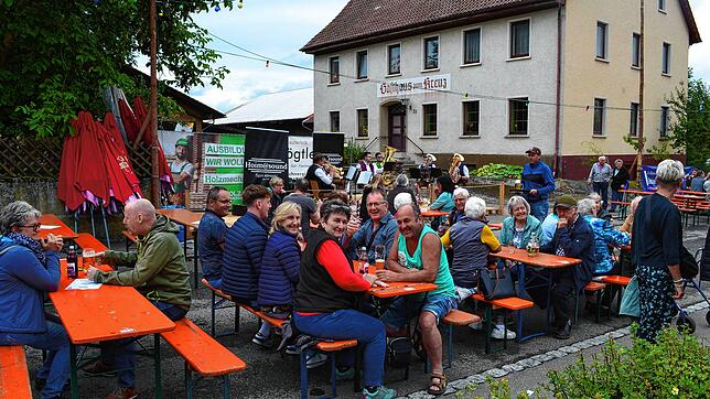 Wegen Platzmangels beim Dorfplatzfest wird die für den Verkehr gesperrte Unterdorfstraße genutzt. Im Hintergrund spielt die Musikkapelle ...