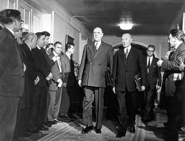 Der damalige französische Staatspräsident Charles de Gaulle (M) und der damalige deutsche Bundeskanzler Konrad Adenauer (rechts neben de ...