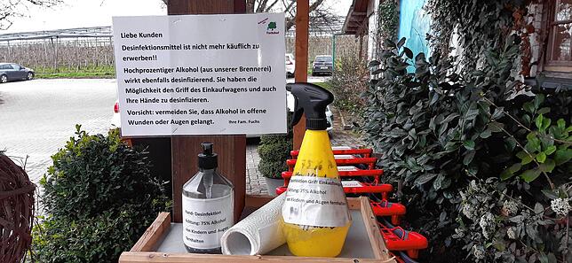 Vor dem Fuchshof können Kunden Einkaufswagen und Hände mit selbst hergestelltem Desinfektionsmittel besprühen.