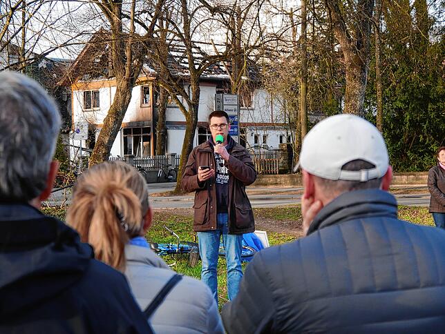 Gemeindeleiter Maximilian Stroscher bei einem Gottesdienst kurz nach der Brandnacht. Im Hintergrund sind Teile der zerstörten ...
