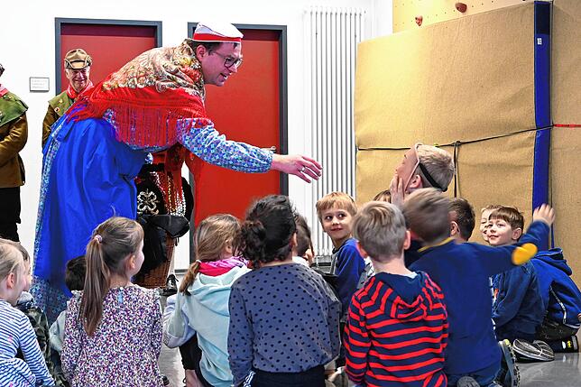 Ein Schüler probiert die Maske einer der Schnitzwieber.