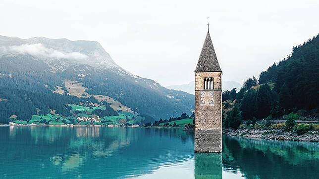 Der Kirchturm des alten Dorfs Graun, das vom Stausee am Reschenpass überflutet wurde, ist allein ein Grund, einmal auf dieser Route nach ...