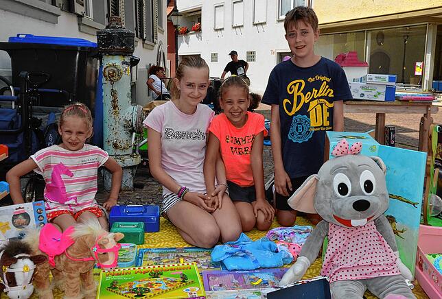 Hanna, Jona, Laura und Joschua bieten auf dem Kinderflohmarkt Spielsachen an.