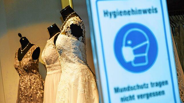 Ein Schild zur Maskenpflicht vor einem Schaufenster eines Modegeschäfts. Die Debatte, wann die Pflicht zum Tragen einer FFP2- oder ...