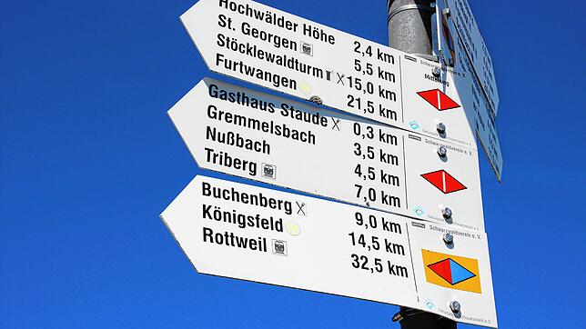 Ein Wegweiser am Parkplatz beim Gasthaus &bdquo;Staude&ldquo;. Abgebildet sind die Symbole für zwei große Wanderwege des ...