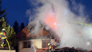 Über die Drehleiter, vom Dach einer Garage und von einer Tragleiter aus bekämpfen Feuerwehrleute am Sonntagmorgen das Feuer in dem ...