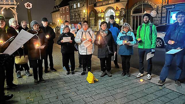 Menschen stehen in der Hauptstraße in Stockach und halten Kerzen in der Hand zu Gedenken an die Opfer der Reichspogromnacht im November ...