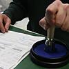 Ein Zöllner stempelt einen Antrag eines Schweizer Kunden auf Rückerstattung der Mehrwertsteuer ab.