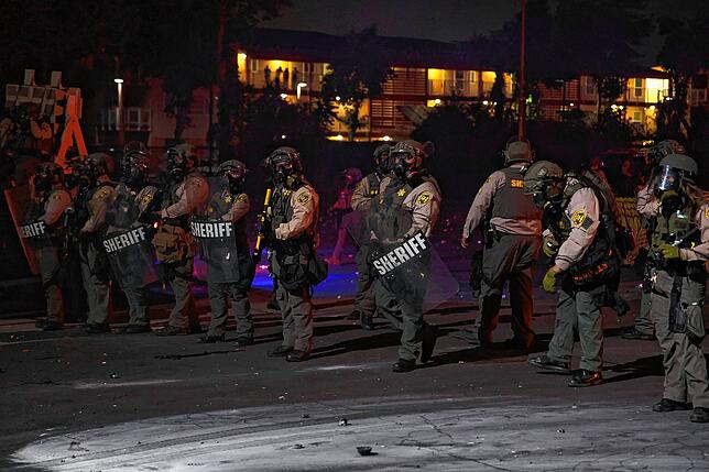 Los Angeles County Sheriffs stehen in Schutzanzügen bereit. Am Freitag griffen rund 1.000 Demonstranten ICE-Beamte an. Die örtliche ...