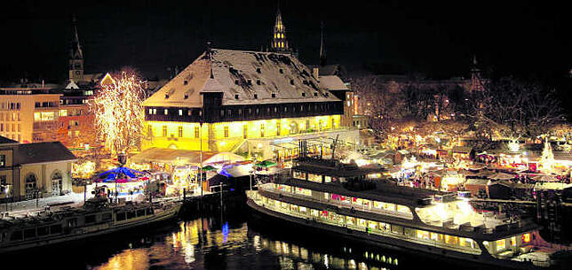 Lichterzauber vor schwarzem Abendhimmel: Der Konstanzer Weihnachtsmarkt hat sich bis an das Seeufer ausgedehnt.