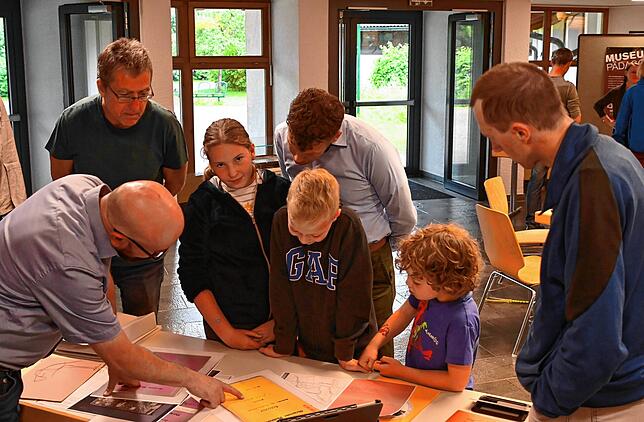 Dominik Rimmele (links) erklärt Akten aus früheren Zeiten und hilft den Kindern, die Handschriften zu entziffern.