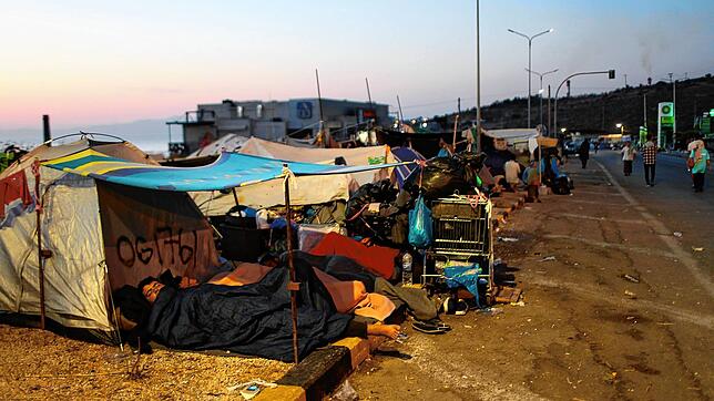Flüchtlinge schlafen am Rand einer Straße, die von Moria nach Mytilene führt, vor ihrem Zelt.
