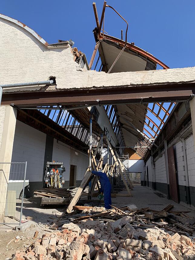 Stück für Stück wird das Dach der abgrebrannten Fabrikhalle in Handarbeit abgerissen.