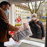 Juso-Mitglied Leon Huber (links) nimmt eine Tüte mit Sachspenden am Fenster des SPD-Fraktionsbüros entgegen.