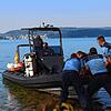 Mit vereinter Kraft schieben die Beamten das Boot der Taucher ins Wasser. Dort markiert eine Boje die Fundstelle der Leiche.