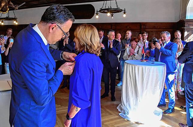 Staatssekretär Siegfried Lorek heftet Elke Bettecken das Bundesverdienstkreuz an.