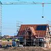 Ein Einfamilienhaus steht im Rohbau in einem Neubaugebiet. Knappes Angebot an Häusern und Bauplätzen sowie eine hohe Nachfrage treiben ...