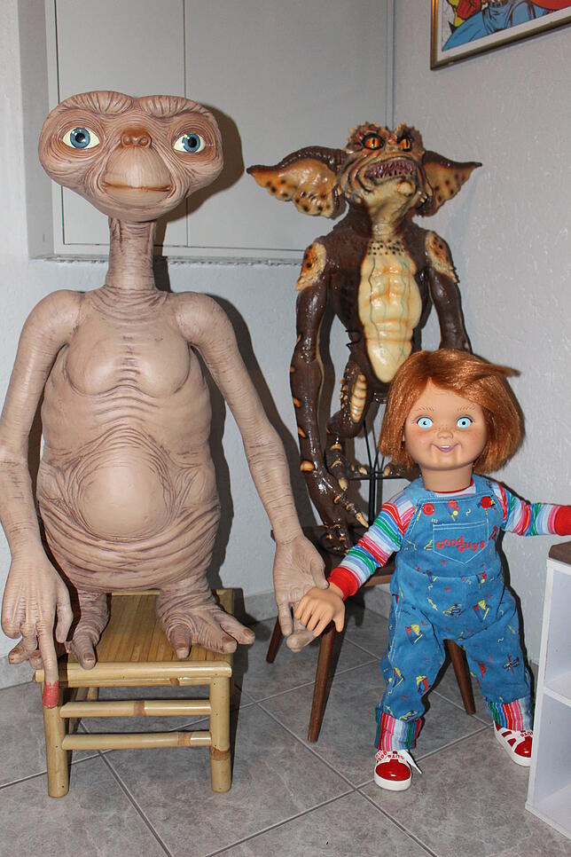 Begrüßung im Hausflur von Filmfiguren in Eins-zu-eins-Größe: E.T. (von links), ein Gremlin und die Good-Guy-Puppe Chucky.