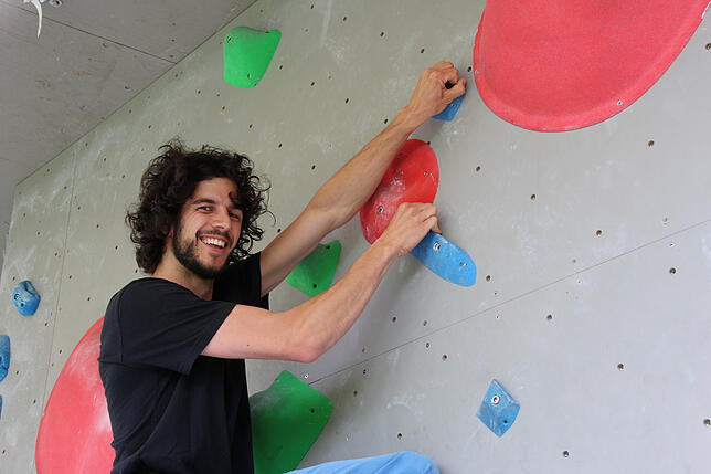 Adrian Flaig testet an der Kletterwand der Uni die eigenen Griffe.