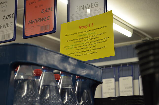 Zettel im Laden weisen die Kunden darauf hin, lieber Mehrweg als Einweg zu kaufen.