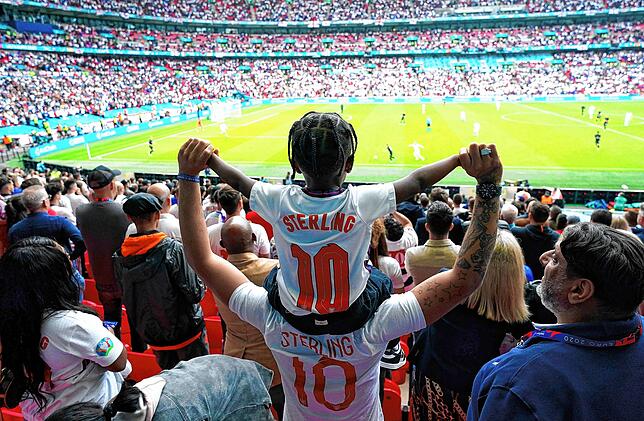 England Fans mit Trikots von Raheem Sterling machen Stimmung auf der Tribüne.