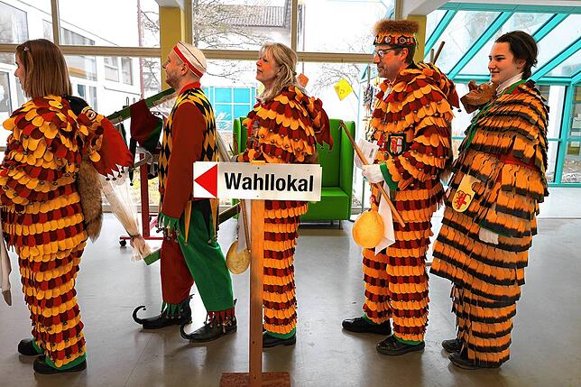 Am Wahllokal Hausherrenschule stehen Gardisten und Mitglieder der Klepperlegruppe an.