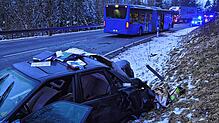 Das Wrack des Audi liegt im Vordergrund im Straßengraben, hinten ist der stark beschädigte Linienbus zu sehen.