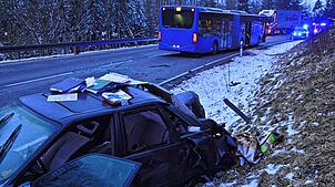 Das Wrack des Audi liegt im Vordergrund im Straßengraben, hinten ist der stark beschädigte Linienbus zu sehen.