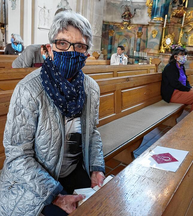 Markierte Plätze: Eine Kirchgängerin sitzt in der Bank an der Stelle, wo vor ihr das Zeichen der Seelsorgeeinheit Mittlerer Hochrhein zu ...