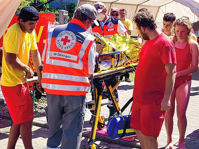 Der verletzte Wassersportler wird mit einer fahrbaren Trage in den DRK-Krankentransportwagen gebracht.