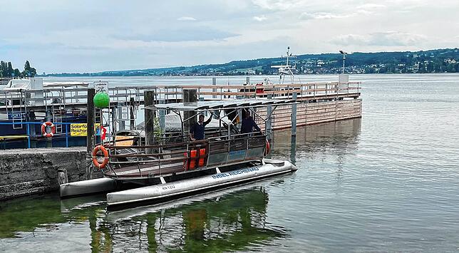 Alexander Stenzel (links) und Christian Rieck (rechts) mit dem Solarboot im Hafen auf der Reichenau