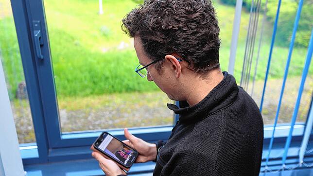Thorsten W. blickt auf seinem Smartphone auf ein Bild der Frau, die sich Yoona nennt. Der Konstanzer verlor in wenigen Wochen ein ganzes ...