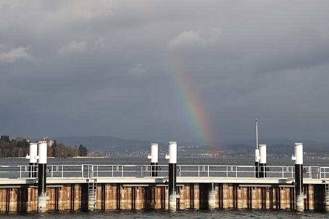 Vom Fährhafen aus ist dieses Bild entstanden. Der Regenbogen scheint irgendwo zwischen Überlingen und Unteruhldingen zu verschwinden.