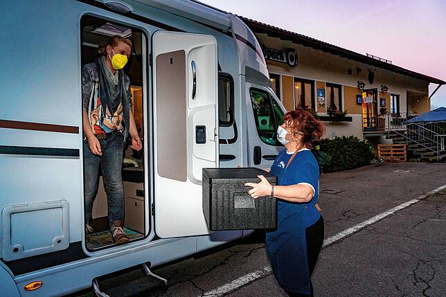 Hier kommt das Essen: Bianca Wälde überbringt die bestellten Speisen in der Warmhaltebox an Daniela Schütt, die schon in ihrem Wohnmobil ...