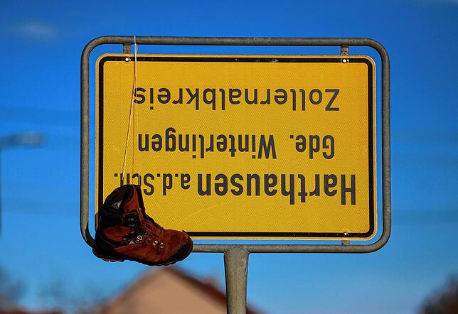 Unbekannte haben das Ortsschild von Harthausen umgedreht und einen Schuh an das Schild gehängt.