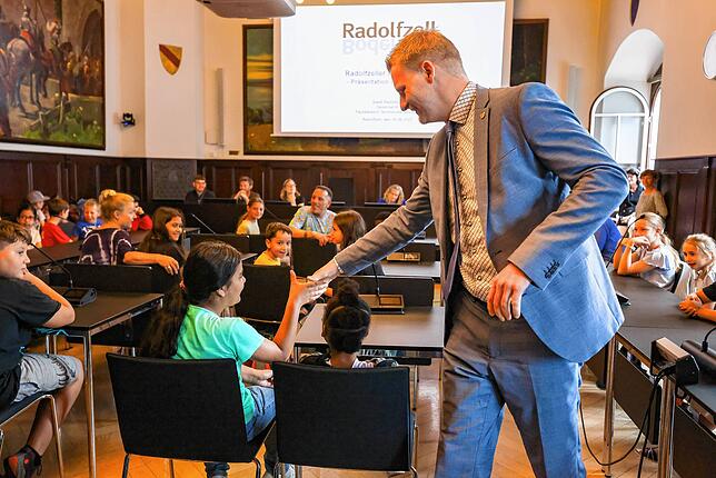 Jeder wird mit Handschlag persönlich durch den Oberbürgermeister begrüßt: Simon Gröger gibt einem Mädchen beim Kinderforum die Hand.