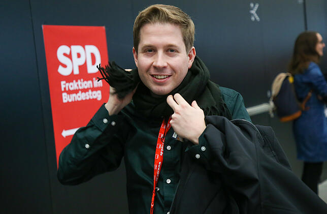 Kevin Kühnert, Bundesvorsitzender der Jusos, wickelt sich beim SPD-Bundesparteitag einen Schal um seinen Hals.