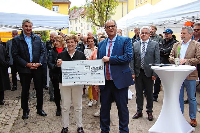 Nicole Razavi (mitte) übergibt an Oberbürgermeister Jürgen Roth (rechts) einen Scheck über 2,9 Millionen Euro aus der Städtebausanierung ...