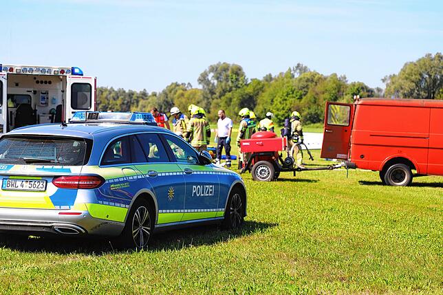 Rettungskräfte, Polizei und Feuerwehr sind mit vielen Kräften im Einsatz. Im Hintergrund ist das kleine Ultraleichtflugzeug.