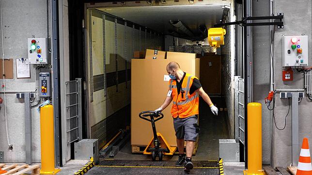 Mit Hilfe von Hubwagen werden die großen Kartons, Gaylords genannt, in die Halle des Verteilzentrums gefahren.