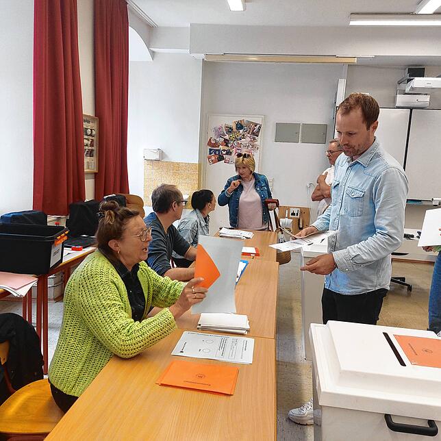 Markus Bettecken holt sich seine Wahlunterlagen im Wahllokal Karl-Brachat-Realschule ab. Wahlhelferin Bärbel Walz (links) händigt ihm ...