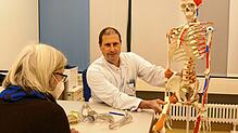 Professor Björn Gunnar Ochs, Chefarzt für Unfallchirurgie, Handchirurgie und Orthopädie am Klinikum Konstanz, erläutert einer Patientin ...