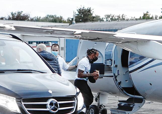 Kein Blick von Lewis Hamilton zu der Handvoll Fans, die am Privtajet auf ihn warten. Mit Mundschutz eilt der Formel 1-Star zurück in den ...