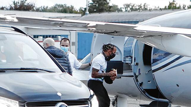 Kein Blick von Lewis Hamilton zu der Handvoll Fans, die am Privtajet auf ihn warten. Mit Mundschutz eilt der Formel 1-Star zurück in den ...