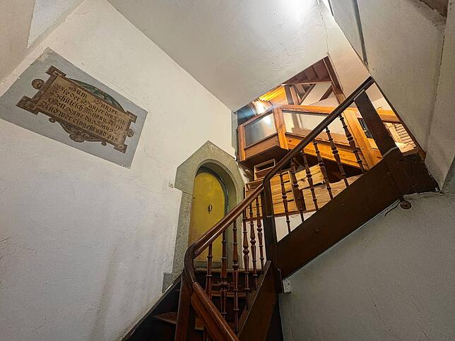 Viele kleine Treppen ziehen sich durch das verwinkelte Haus. Links steht die Inschrift „Zum Panzer“ geschrieben.
