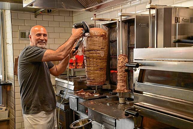 Zafer Ekincioglu schabt bei fast 50 Grad das Fleisch vom Dönerspieß.
